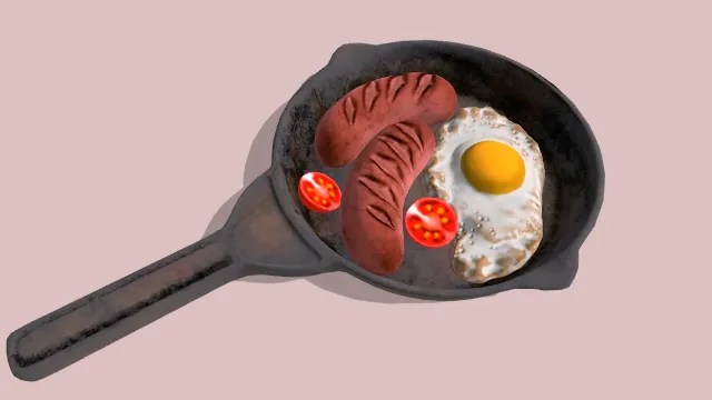 小锅放有煎蛋配香肠和西红柿